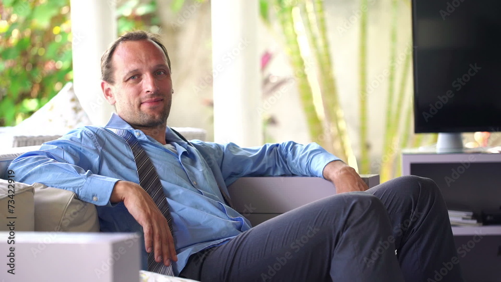 Portrait of happy, relaxed businessman sitting on sofa at home Portrait of happy, relaxed businessman sitting on sofa at home
