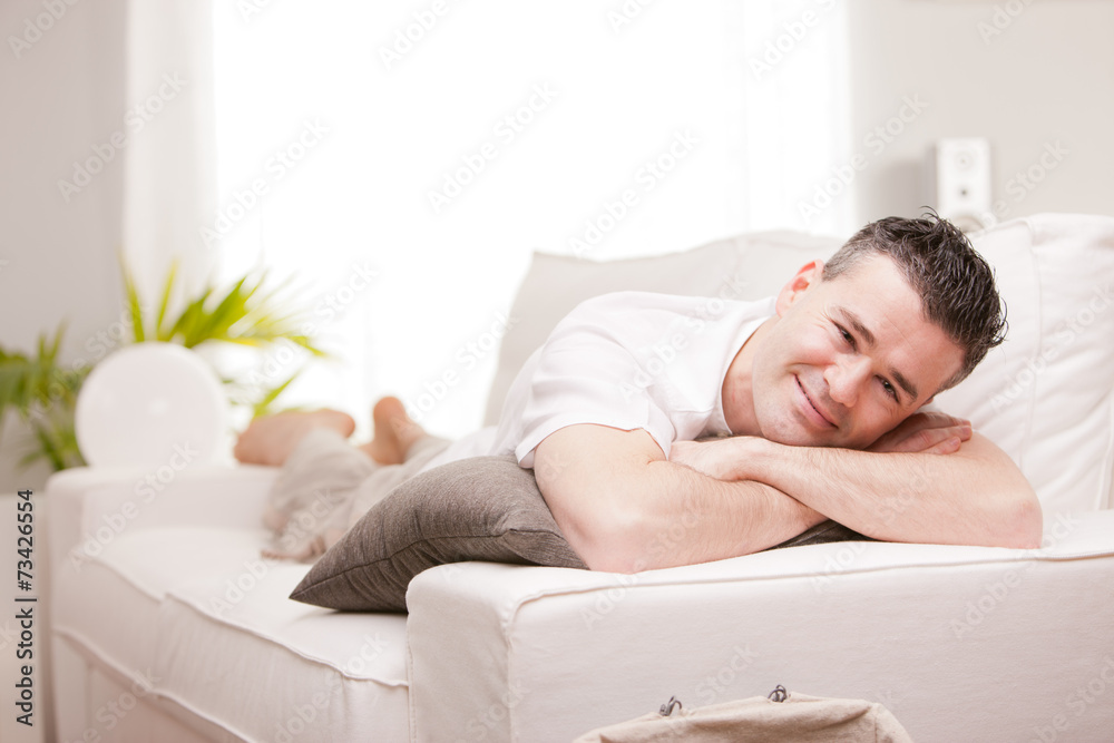 man smiling to camera relaxing in his living room man smiling to camera relaxing in his living room