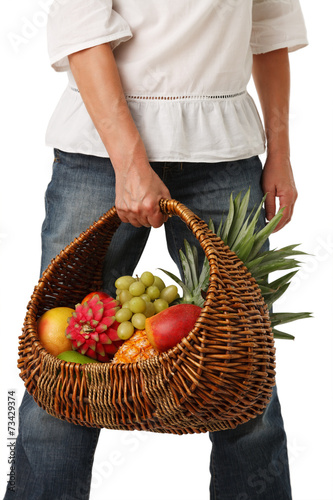 Fruit basket in hands of women.