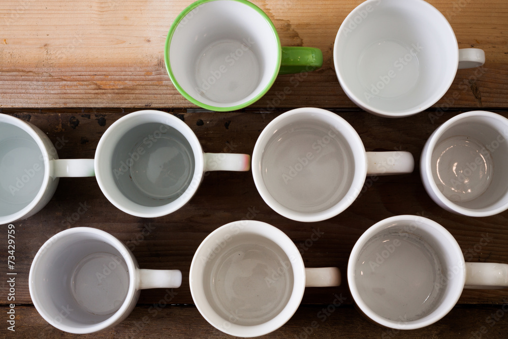 Group of different mugs on wooden table Group of different mugs on wooden table