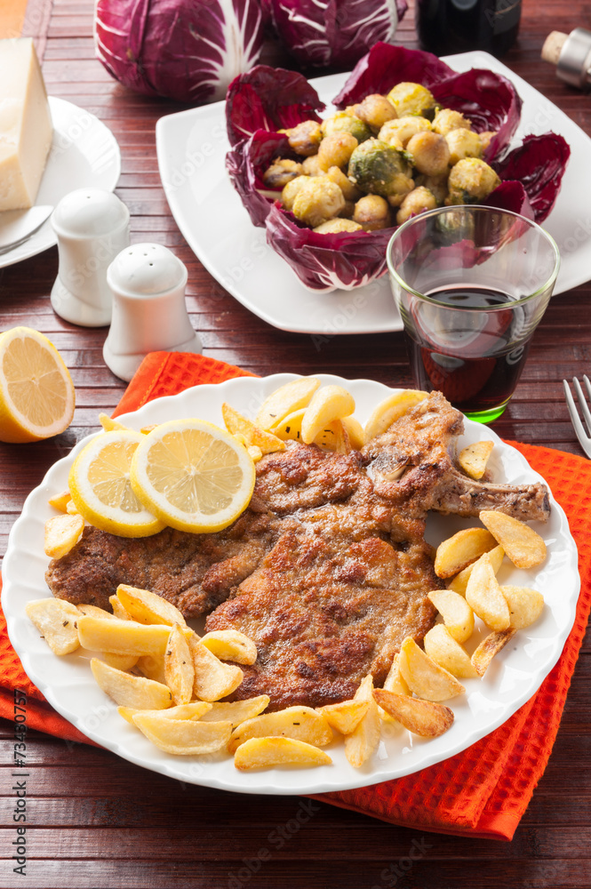 Foto Stock Cotoletta alla milanese o orecchia d’elefante con patatine Adobe Stock