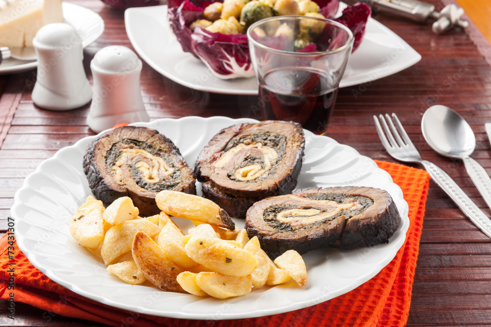 Arrosto farcito con spinaci a fette con patate fritte Arrosto farcito con spinaci a fette con patate fritte