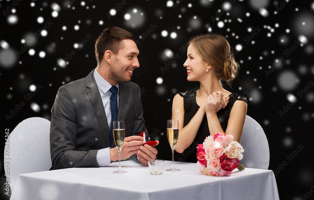 smiling couple with red gift box at restaurant smiling couple with red gift box at restaurant
