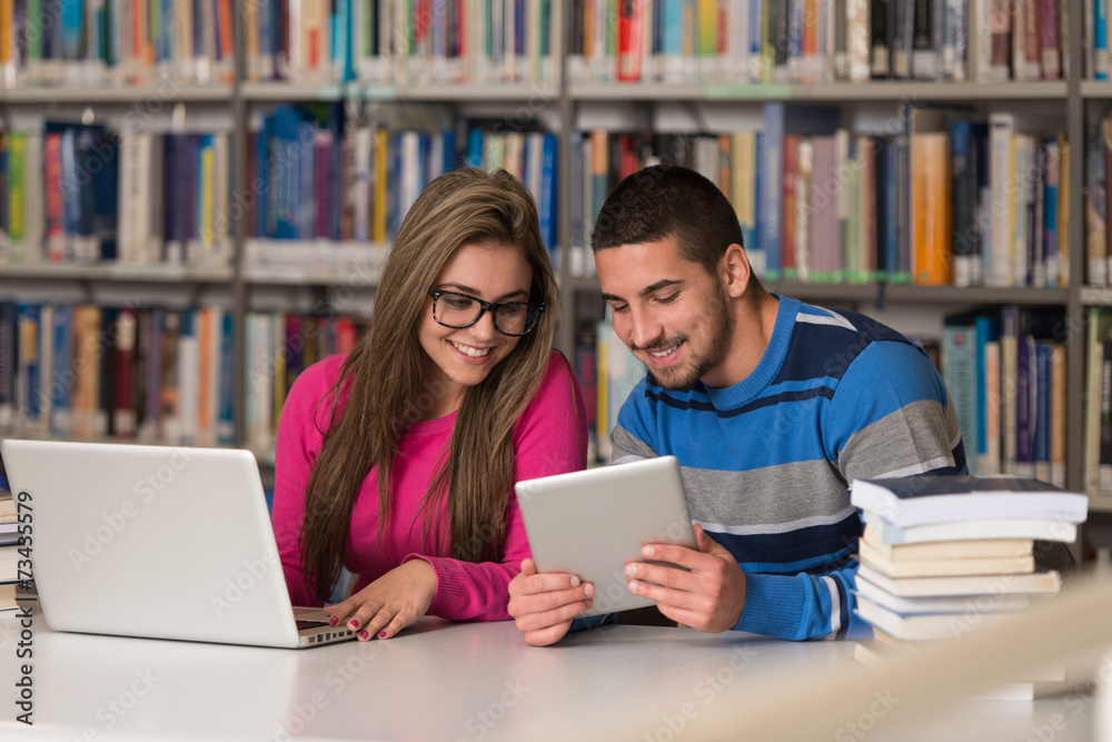 Couple Of Students With Laptop In Library Couple Of Students With Laptop In Library