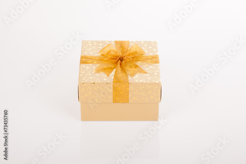 Golden gift box with golden bow on lid