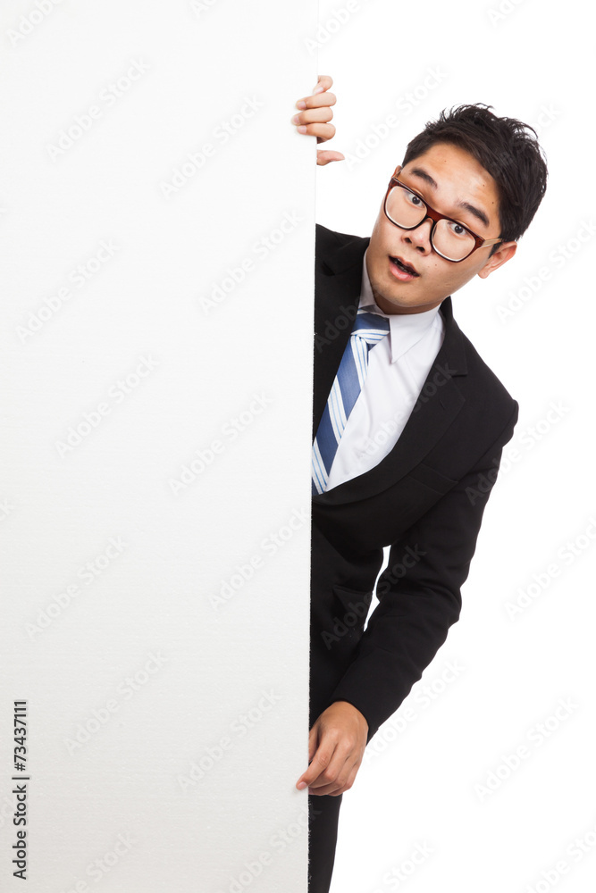 Asian businessman shock peeking from behind blank banner Asian businessman shock peeking from behind blank banner