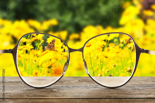 Vision concept. Eye glasses on wooden table outdoors