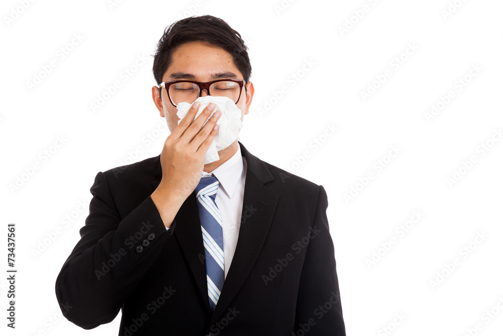 Asian businessman caught cold. Sneezing into tissue. Asian businessman caught cold. Sneezing into tissue.