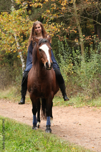 Pretty girl riding a horse without any equipment