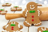 Christmas gingerbread men with rolling pin on white wood