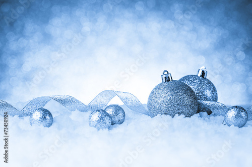 christmas balls in snow on glitter background