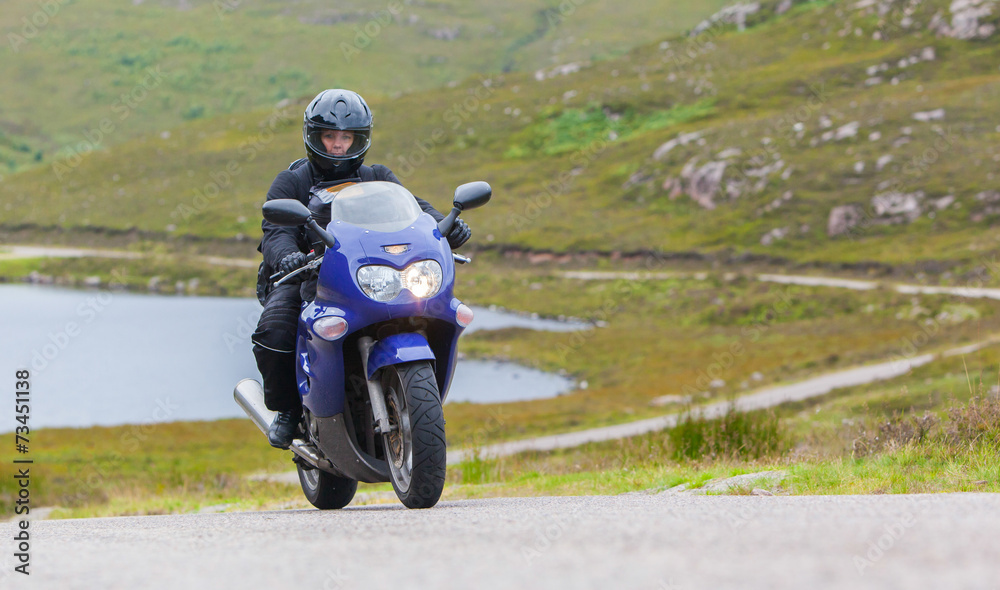 Obraz premium Motocyklista w Scottish Highlands