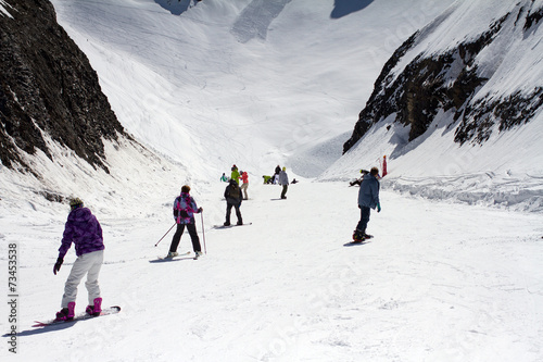 Skiers and snowboarders going down the slope.