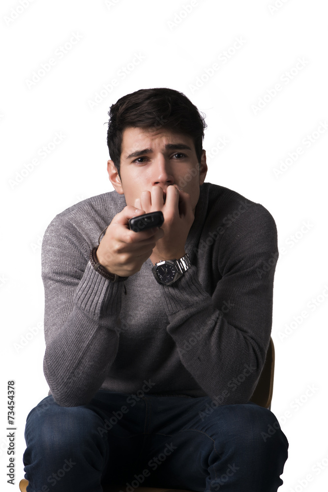 Young man holding remote control and changing TV channels Young man holding remote control and changing TV channels
