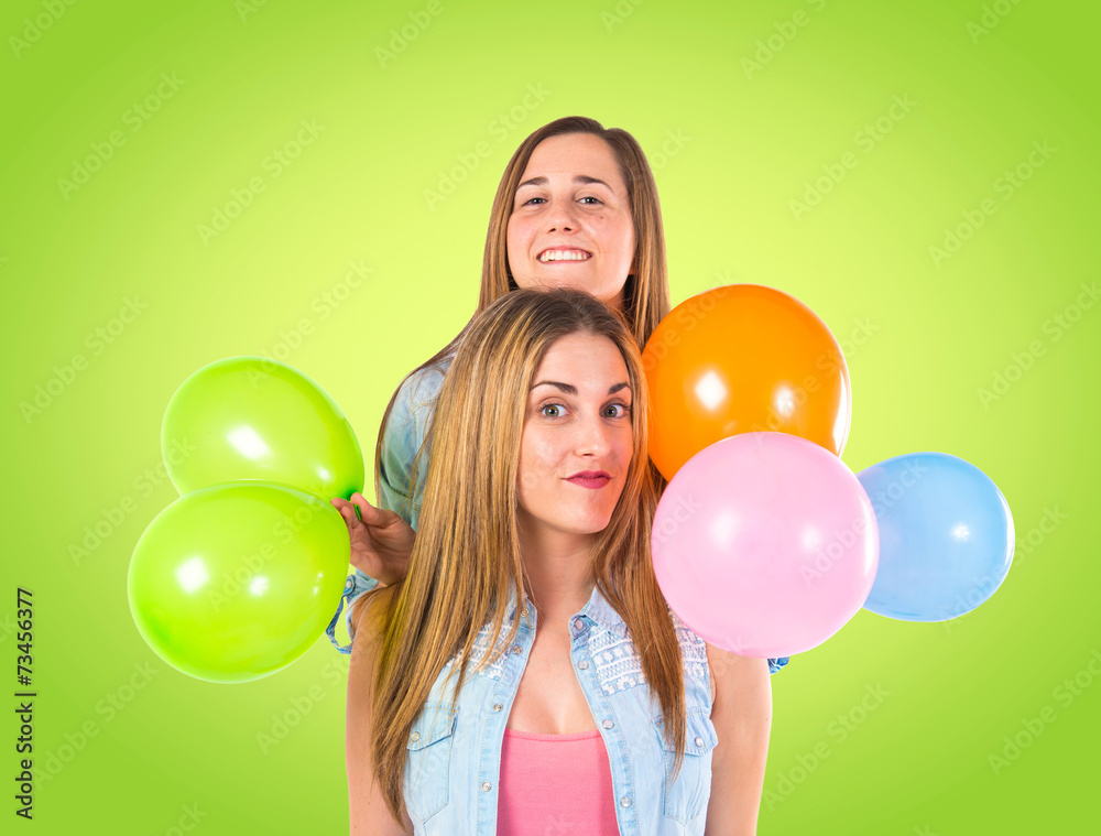 Friends with many balloons over green background Friends with many balloons over green background