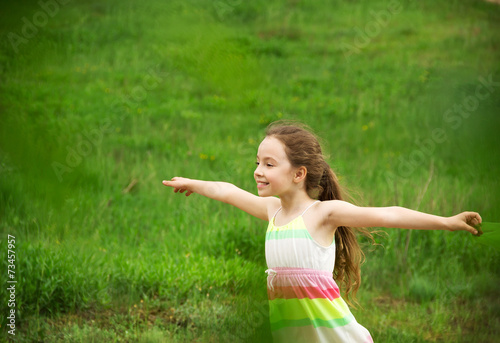 Little girl having fun on a green grass