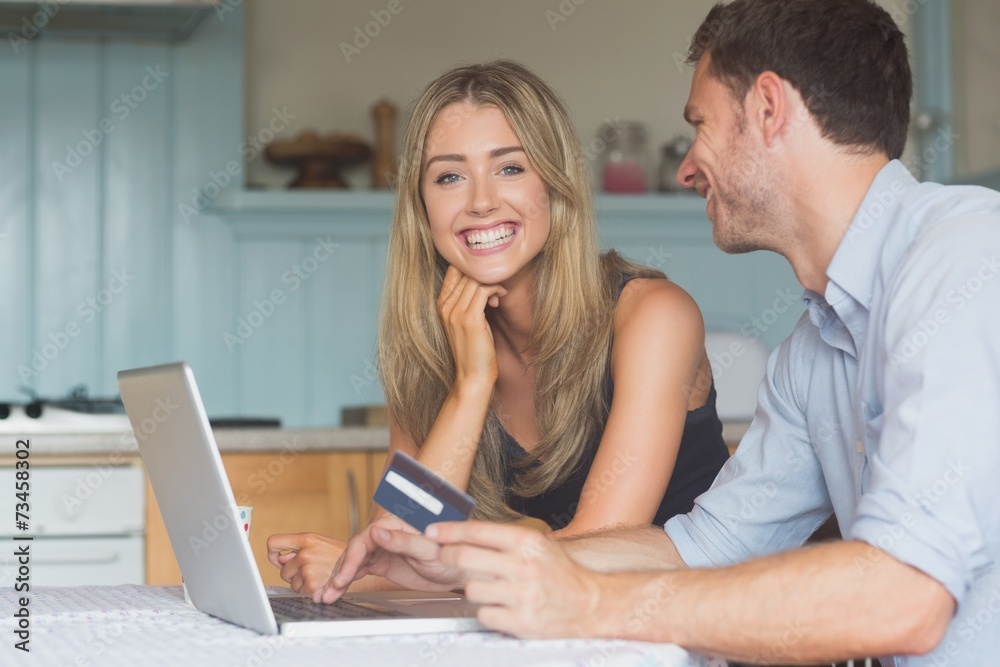 Cute couple using laptop together to shop online Cute couple using laptop together to shop online
