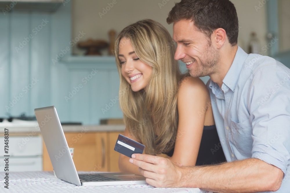 Cute couple using laptop together to shop online Cute couple using laptop together to shop online