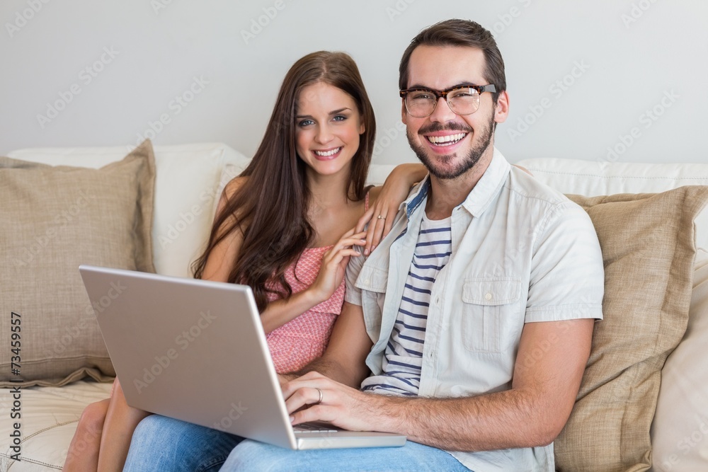 Hipster couple using laptop on couch Hipster couple using laptop on couch