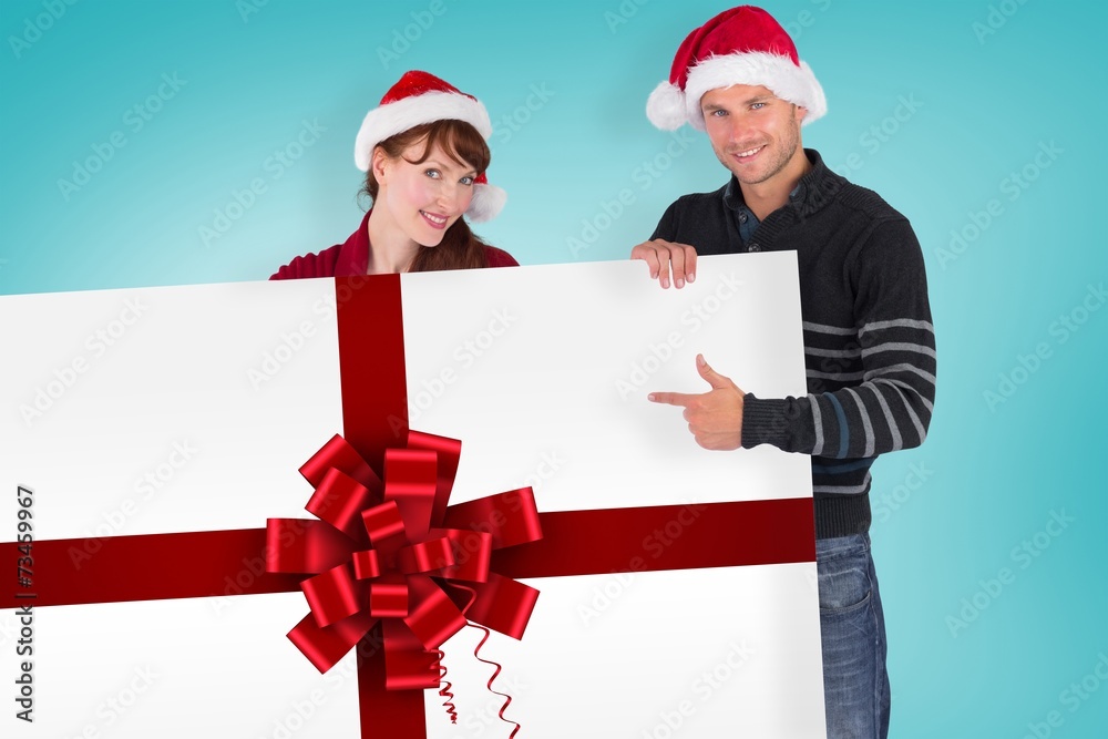 Composite image of couple holding a white sign Composite image of couple holding a white sign