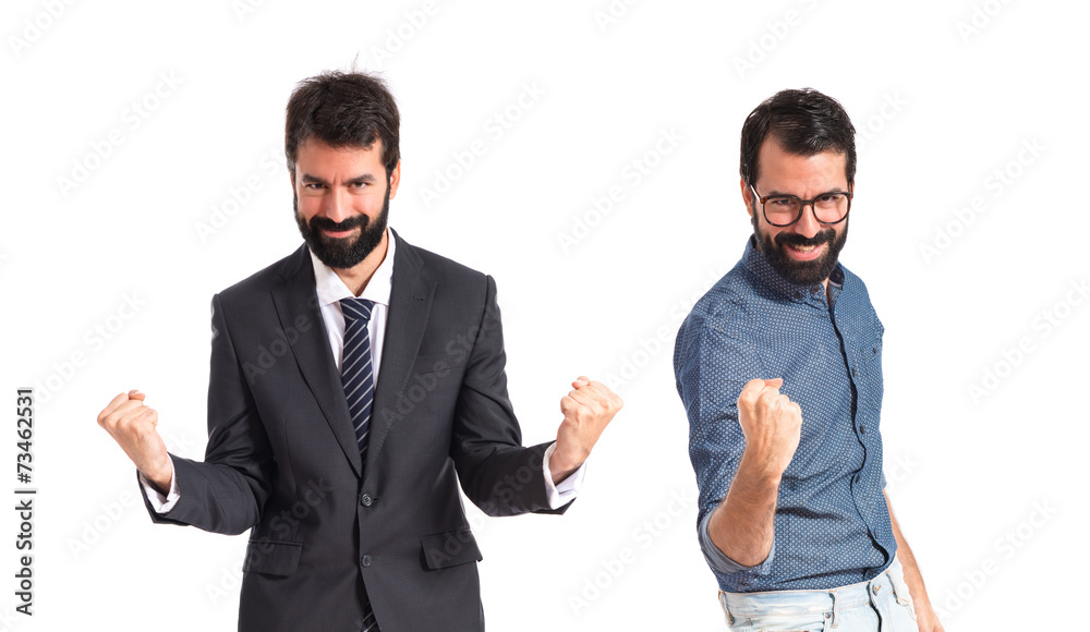 Twin brothers doing victory gesture over white background Twin brothers doing victory gesture over white background