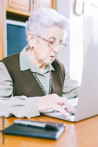 Senior woman with laptop at home