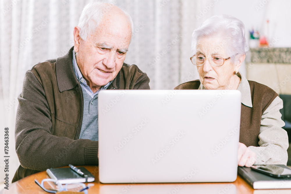 Senior couple working with Laptop at home Senior couple working with Laptop at home
