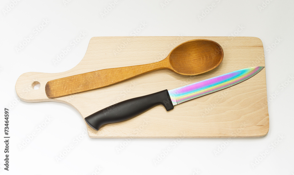 One wooden spoon and knife on the board
