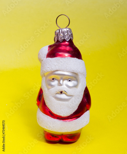 Obraz na płótnie Red toy Santa on yellow background w salonie
