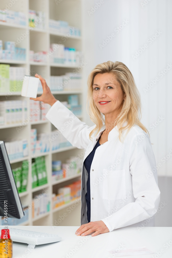 apothekerin nimmt medikament aus dem regal apothekerin nimmt medikament aus dem regal