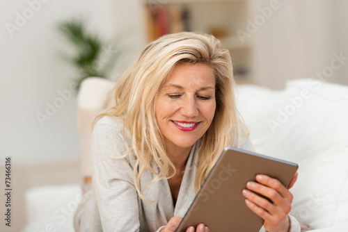 entspannte frau liest ein e-book auf dem sofa