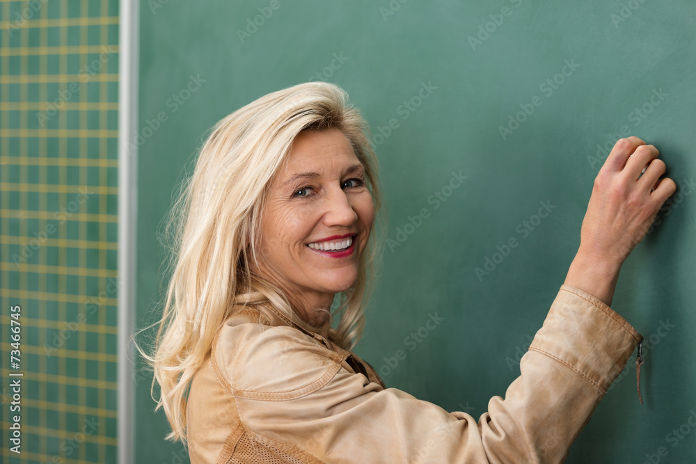 lächelnde lehrerin schreibt an die tafel lächelnde lehrerin schreibt an die tafel
