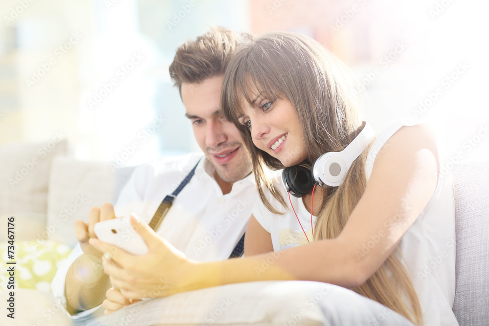 Young trendy couple having fun playing with smartphone Young trendy couple having fun playing with smartphone