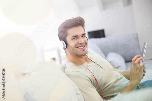 Young man with headphones watching movie on tablet