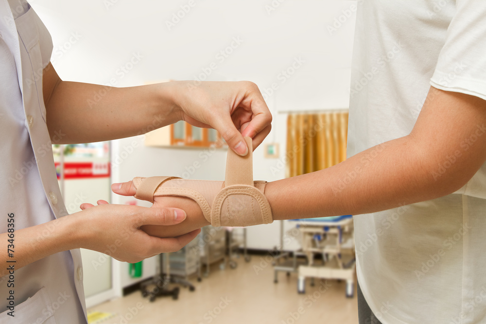 Physical therapist helps woman's patient wearing a wrist brace Physical therapist helps woman's patient wearing a wrist brace