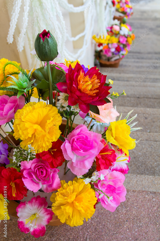Obraz premium Artificial fake flowers placed on the steps of a beautiful