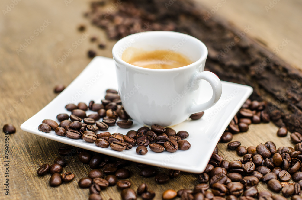 A cup of espresso and coffee beans on an old wooden table :) A cup of espresso and coffee beans on an old wooden table :)