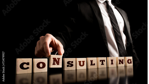 Consultant Arranging Wooden Pieces with ConsultingText photo