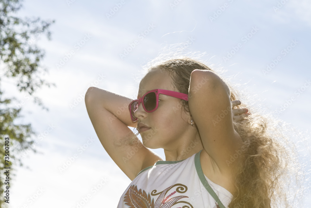 Young girl fixing her sunlit long blond hair. Young girl fixing her sunlit long blond hair.