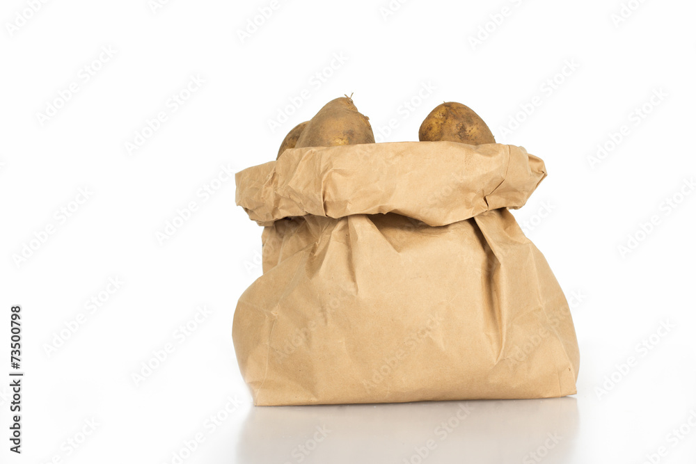 Unwashed potatoes in a paper bag islated on white Unwashed potatoes in a paper bag islated on white