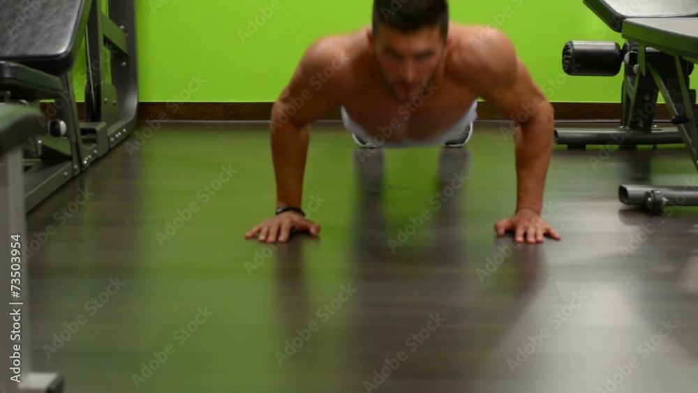 Young adult man doing push ups in gym Young adult man doing push ups in gym