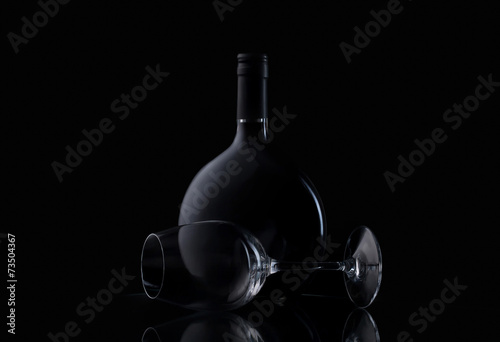 Bottle and glass of wine on black background