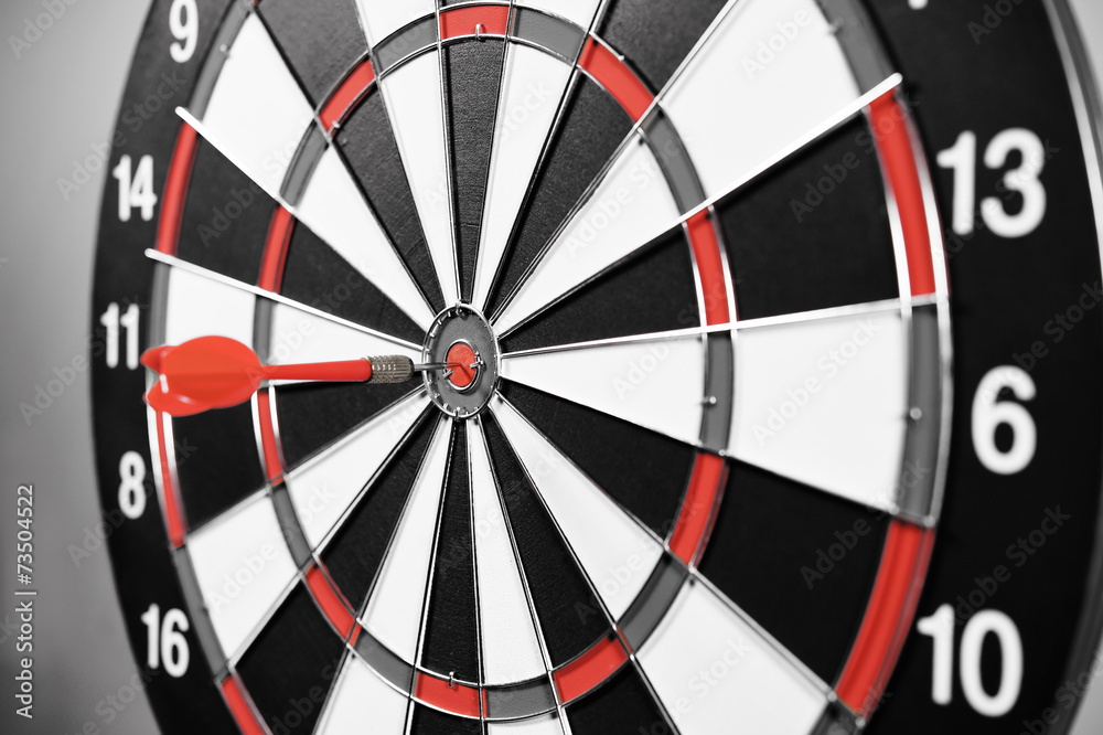 Dartboard with red darts on gray background. Dartboard with red darts on gray background.