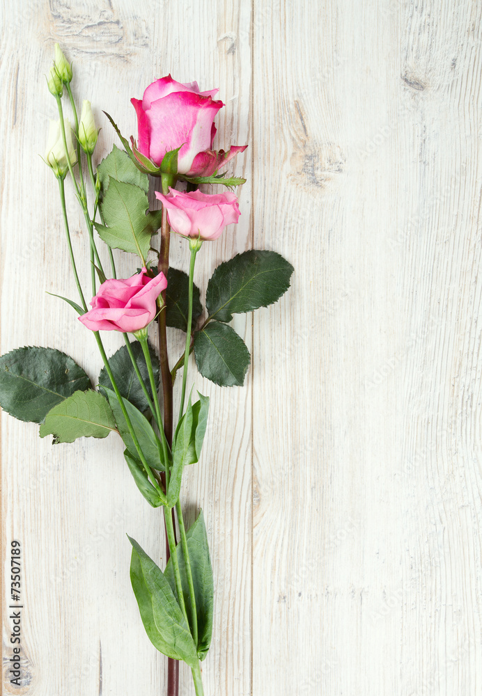 eustoma and roses on wooden surface