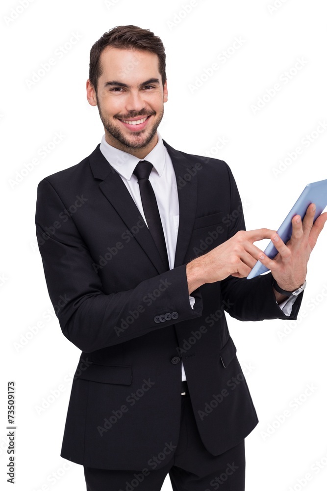 Businessman using his tablet while looking at the camera Businessman using his tablet while looking at the camera