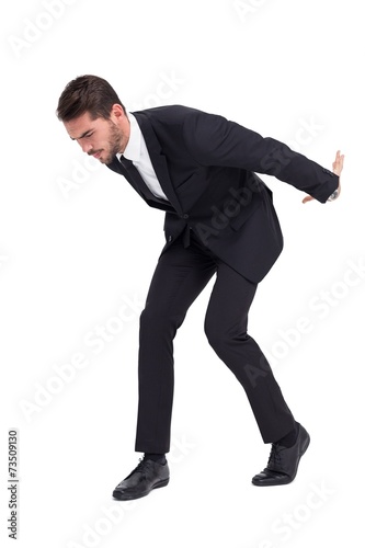 Foto Businessman carrying something heavy with his back and hands