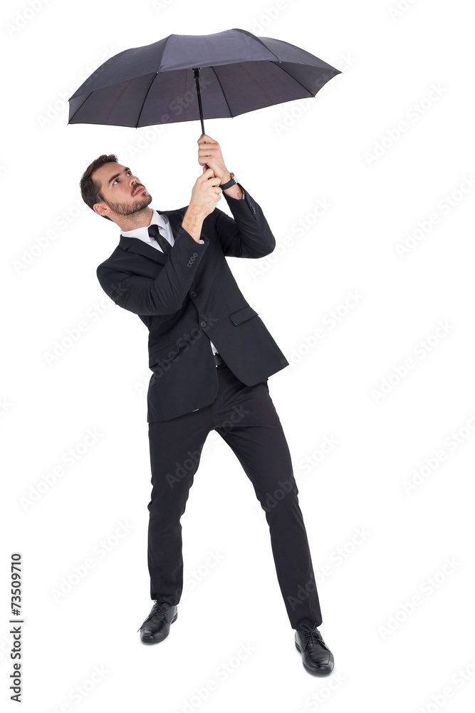 Businessman standing under black umbrella Businessman standing under black umbrella