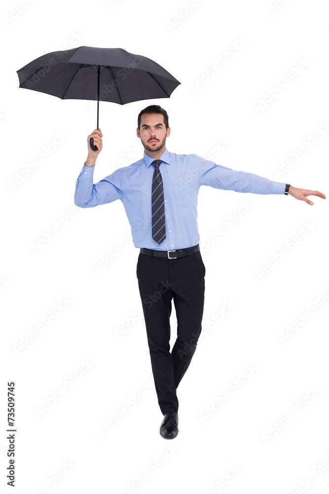 Focused businessman with umbrella balancing Focused businessman with umbrella balancing