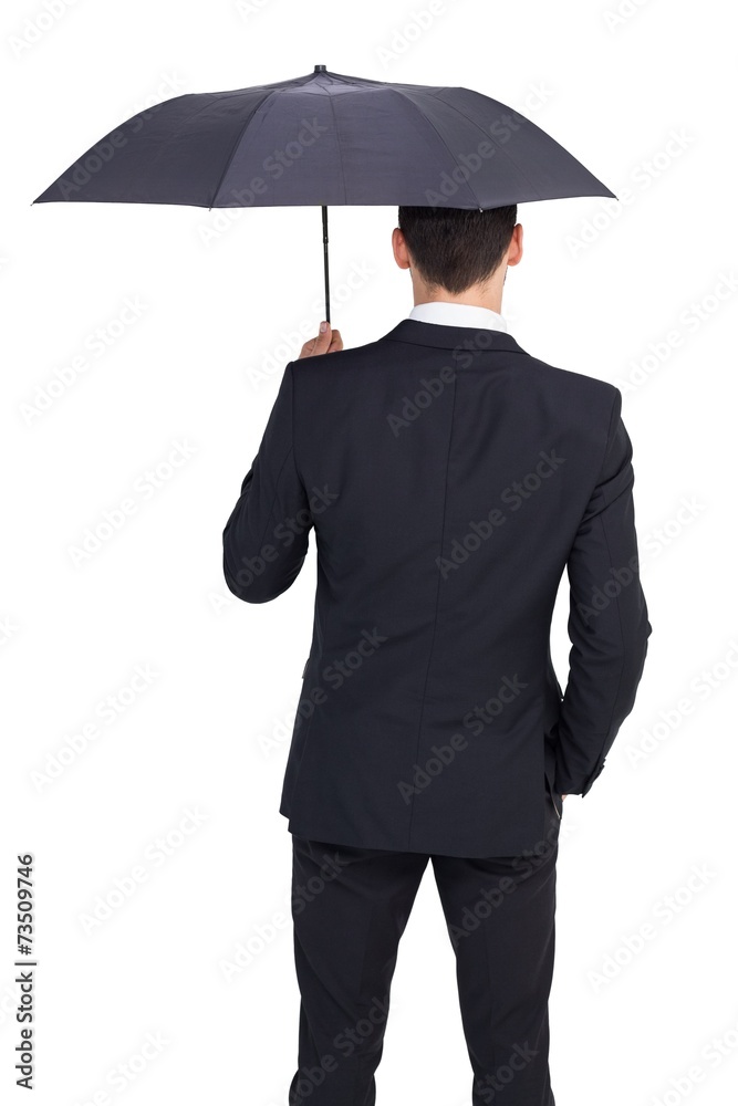 Rear view of businessman sheltering with umbrella Rear view of businessman sheltering with umbrella