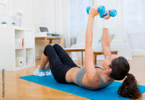 Young attractive girl doing exercise at home